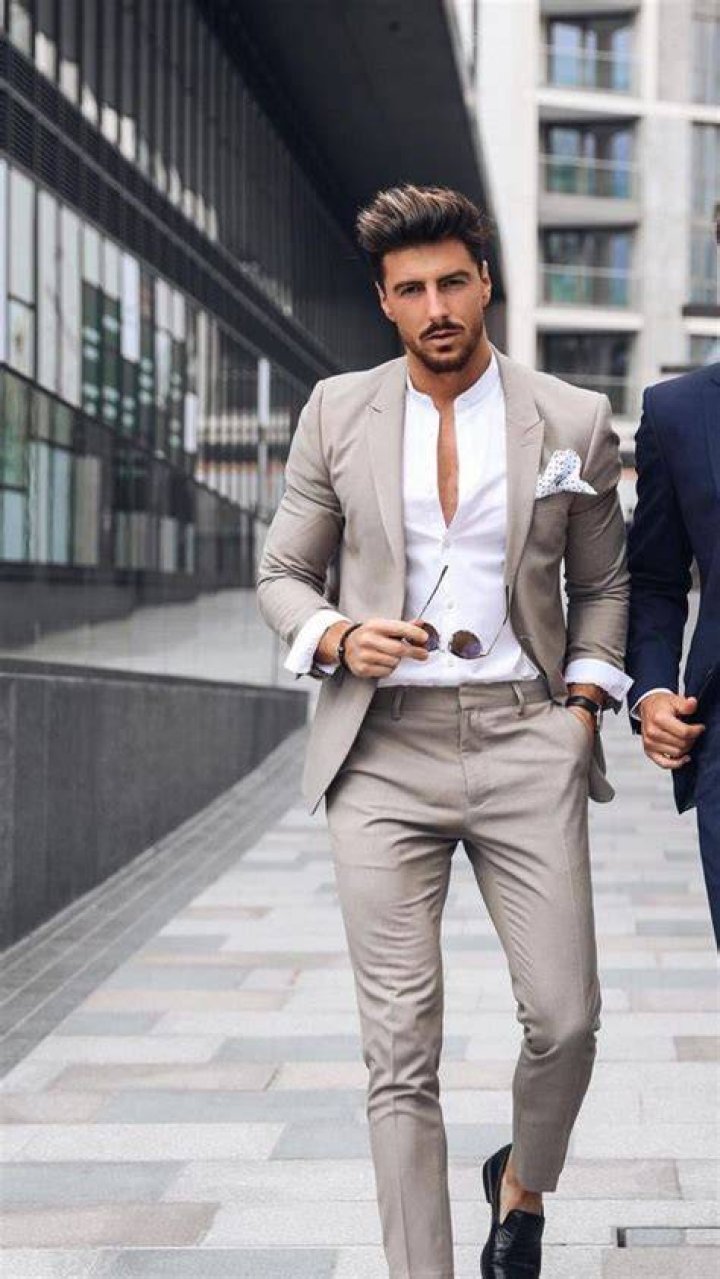 a man in a suit and tie posing for a photo